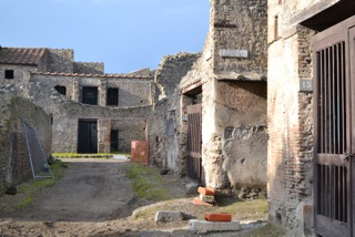 Pompeji, Via di Castricio, Blick auf eine gemalte Inschrift an der Südostecke von Insula I 7